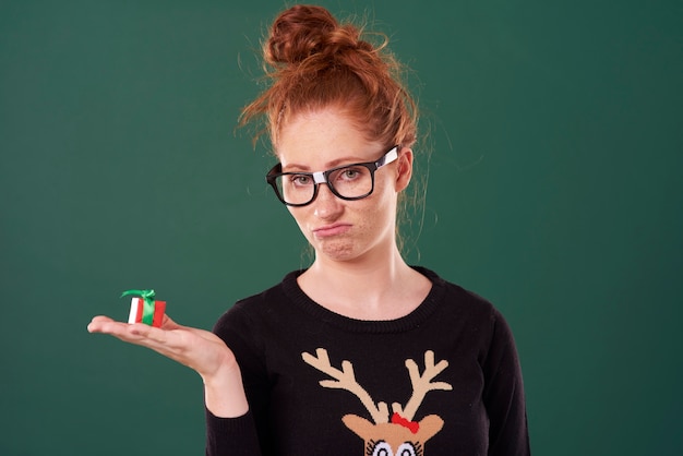 Mulher decepcionada segurando um presente de natal