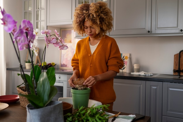 Foto grátis mulher decorando sua casa com orquídeas