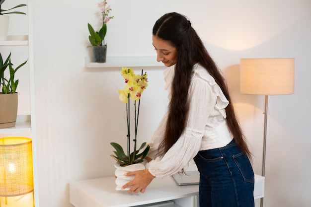 Mulher decorando sua casa com uma flor de orquídea