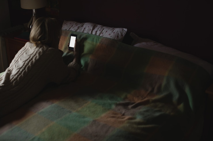 Foto grátis mulher deitada e usando o celular na cama