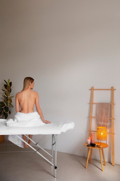 Mulher deitada na cama de massagem pronta para sessão