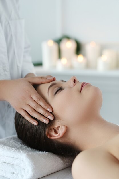 Mulher deitada recebendo uma massagem. Terapia craniossacral
