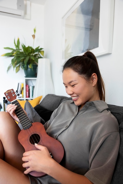 Mulher dentro de casa tocando música no bandolim