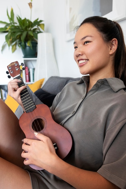 Mulher dentro de casa tocando música no bandolim