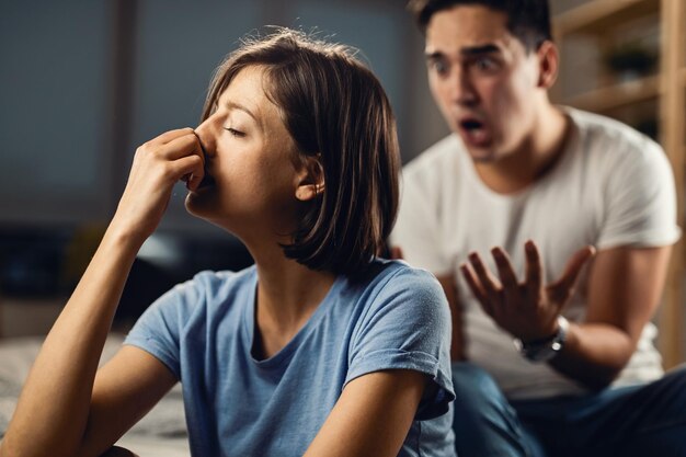 Mulher deprimida se sentindo infeliz em um relacionamento com o namorado e ignorando-o enquanto ele está gritando com ela