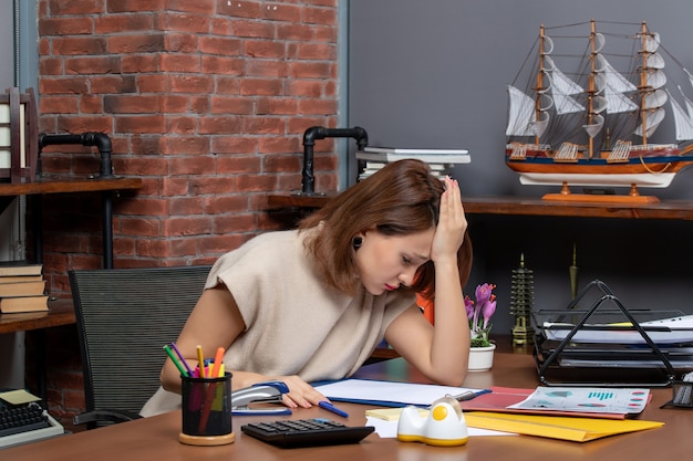 Foto grátis mulher deprimida trabalhando no escritório de frente