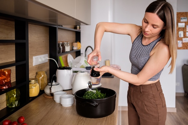 Mulher derramando sal em um vaso com ervas