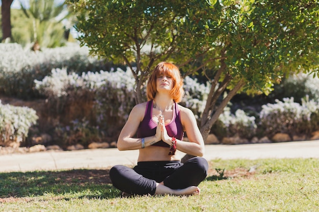 Mulher descalça meditando no parque