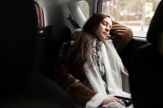 Mulher descansando no carro durante uma viagem de inverno