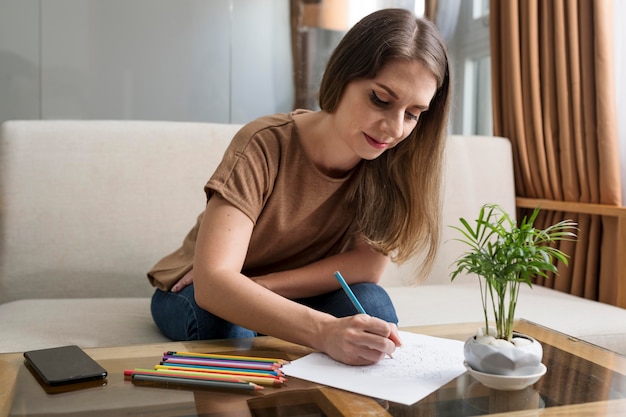 Foto grátis mulher desenhando enquanto faz uma pausa no telefone