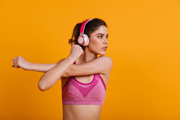 Mulher deslumbrante com fones de ouvido fazendo exercícios aeróbicos