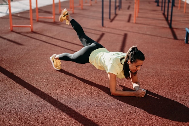 Foto grátis mulher desportiva atraente fazendo exercício de prancha