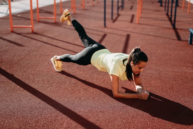 Mulher desportiva atraente fazendo exercício de prancha