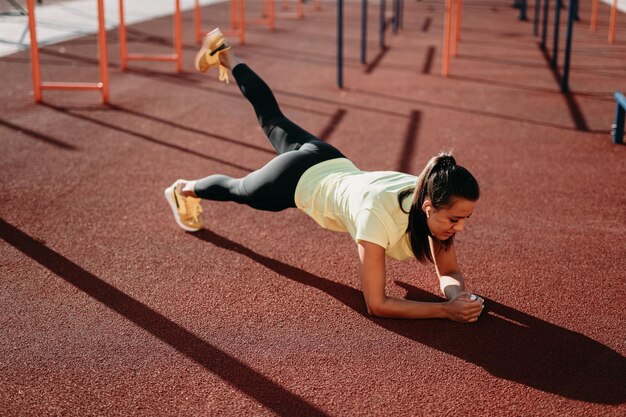 Mulher desportiva atraente fazendo exercício de prancha