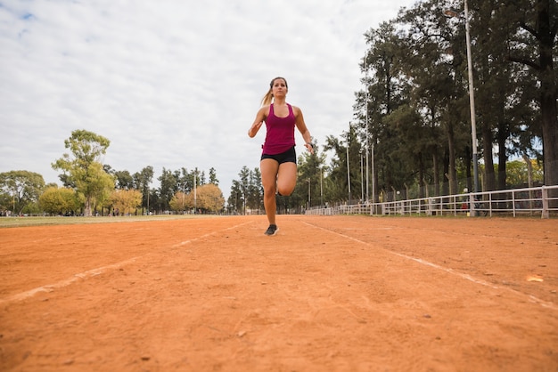 Mulher desportiva correndo na pista do estádio