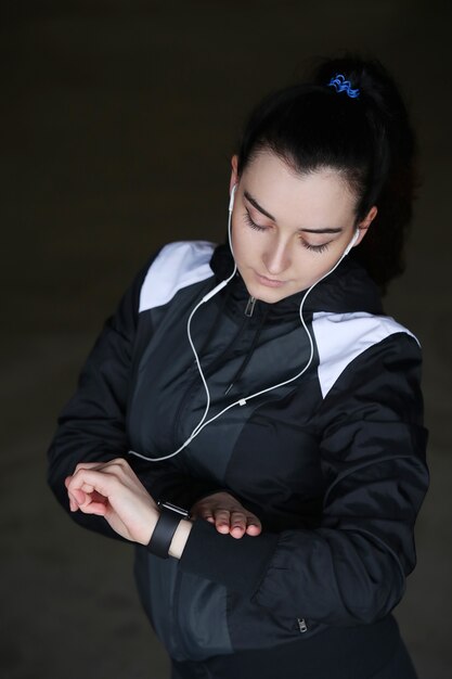 Mulher do esporte ao ar livre olhando seu relógio de pulso