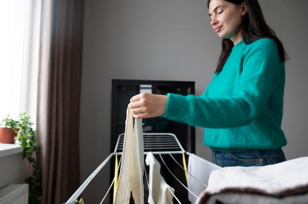 Mulher dobrando toalhas em casa durante a quarentena