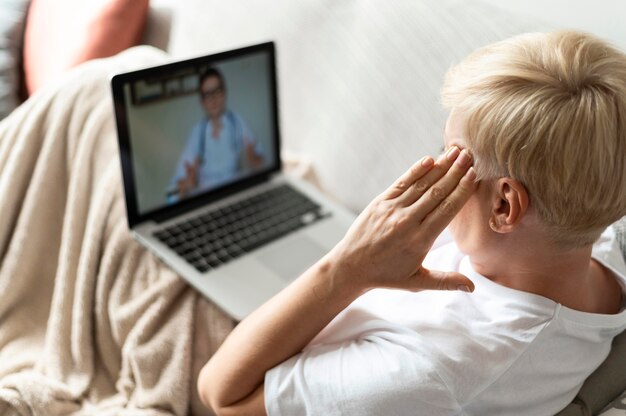 Mulher doente com tiro médio com laptop