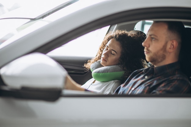 Mulher dormindo em um carro em um travesseiro de carro