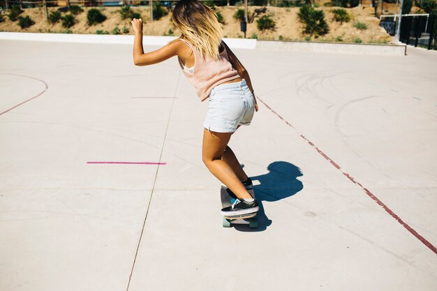 Mulher durante a sessão de skate em um dia ensolarado