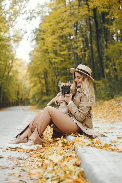 Mulher e cachorro brincam e se divertem no parque de outono