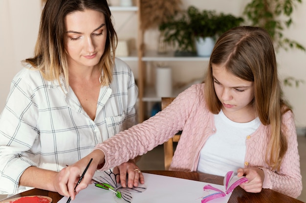 Mulher e criança pintando juntas
