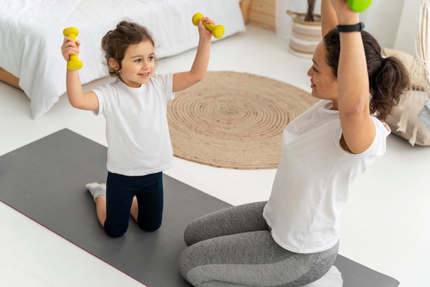 Mulher e criança treinando com halteres