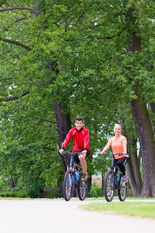 Mulher e homem em mountain bike na floresta