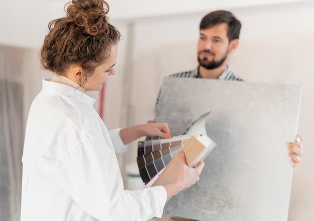 Mulher e homem em plano médio redecorando