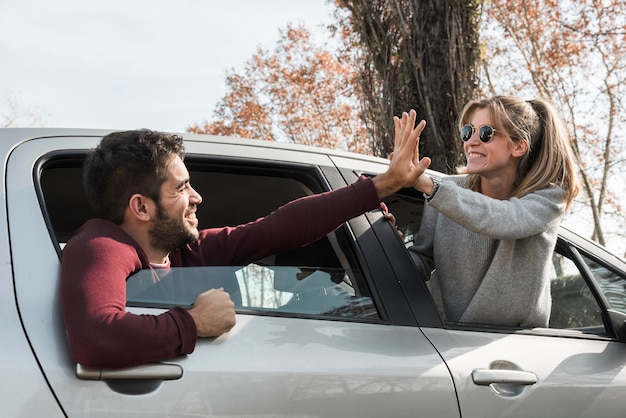 Mulher e homem saindo da janela do carro