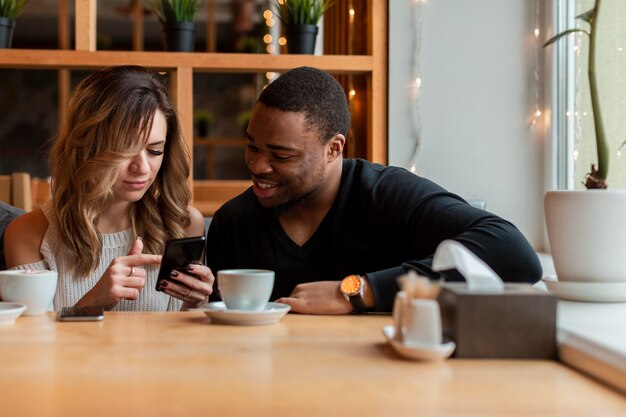 Mulher e homem, verificando seu celular