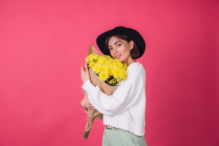 Foto grátis mulher elegante com chapéu na parede vermelha