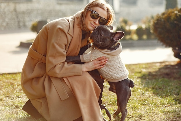 Foto grátis mulher elegante com um casaco marrom com bulldog preto