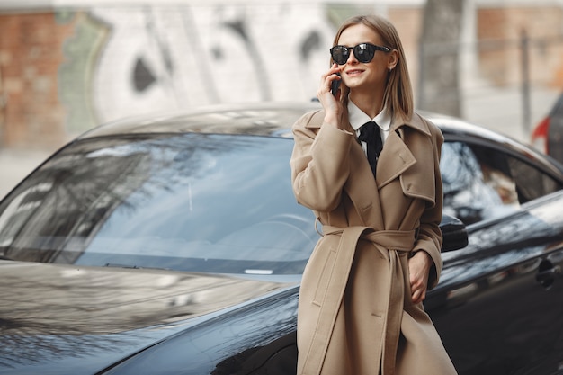 Foto grátis mulher elegante com um casaco marrom em uma cidade de primavera