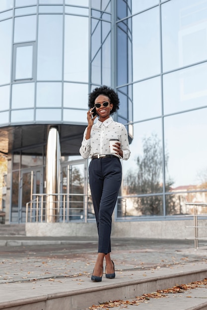 Foto grátis mulher elegante de baixo ângulo, falando por telefone