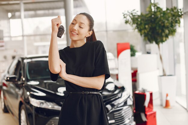 Mulher elegante e elegante em um salão de automóvel