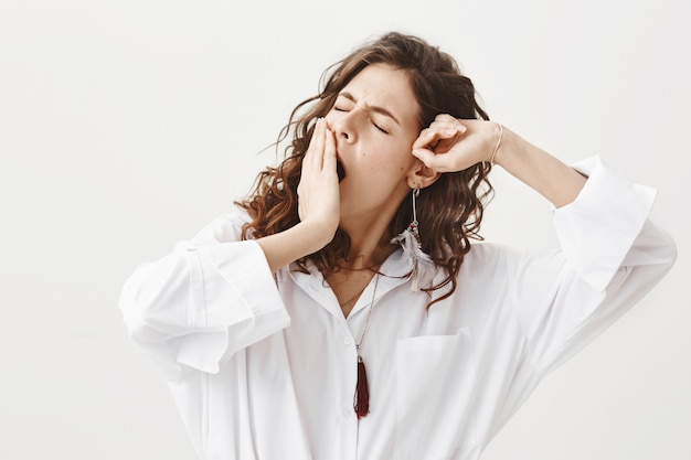 Foto grátis mulher elegante e sonolenta acordando, bocejando e se espreguiçando