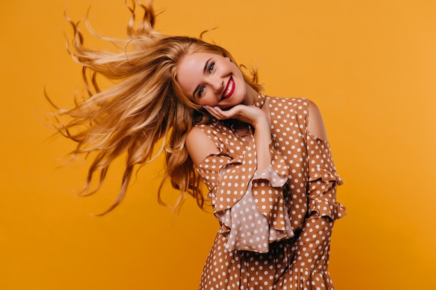 Foto grátis mulher elegante elegante balançando o cabelo. foto interna de uma modelo feminina espetacular usando um traje marrom.