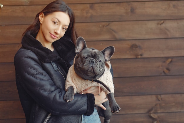 Foto grátis mulher elegante em uma jaqueta preta com bulldog preto