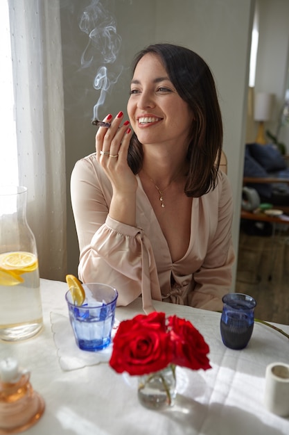 Mulher elegante fumando um baseado em casa