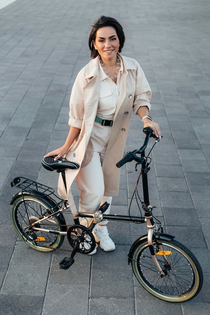 Foto grátis mulher elegante posando com bicicleta ao ar livre