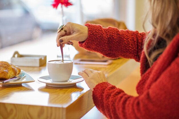 Mulher elegante que agita café