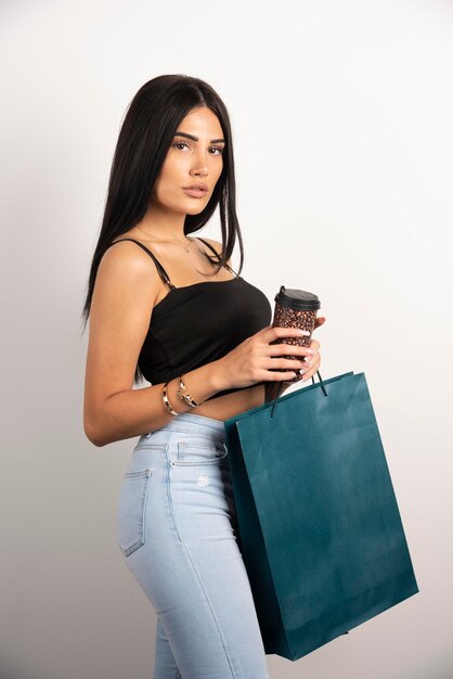 Foto grátis mulher elegante segurando café e sacolas de compras. foto de alta qualidade