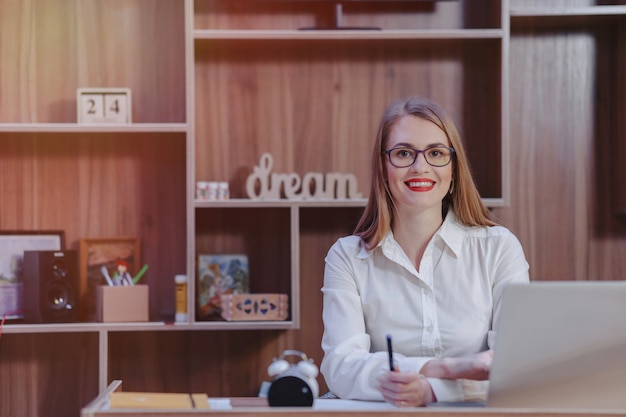 Mulher elegante trabalha em uma mesa de laptop em um escritório moderno