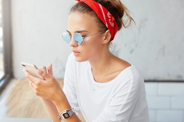 Mulher elegante usando bandana sentada em um café