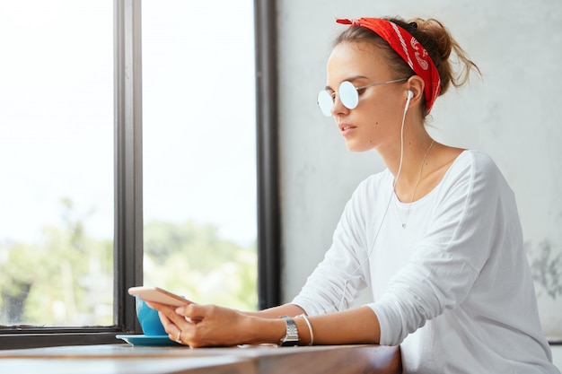 Mulher elegante usando bandana sentada em um café