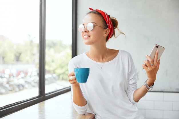 Mulher elegante usando bandana sentada em um café