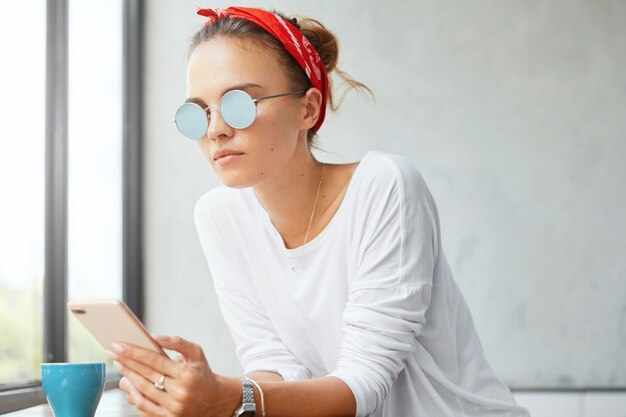 Mulher elegante usando bandana sentada em um café