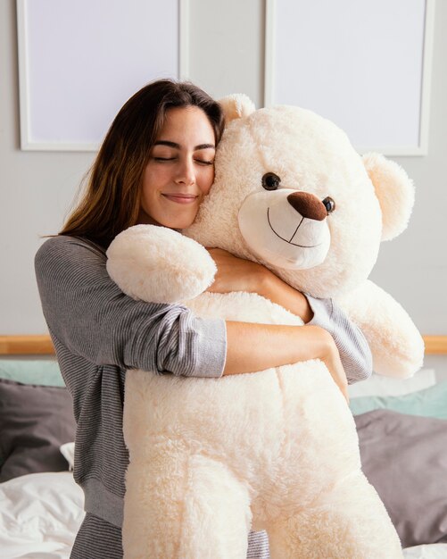 Mulher em casa abraçando o grande urso de pelúcia