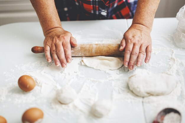 Mulher em casa amassando massa para cozinhar pão ou pizza. Conceito de comida caseira. Estilo de vida